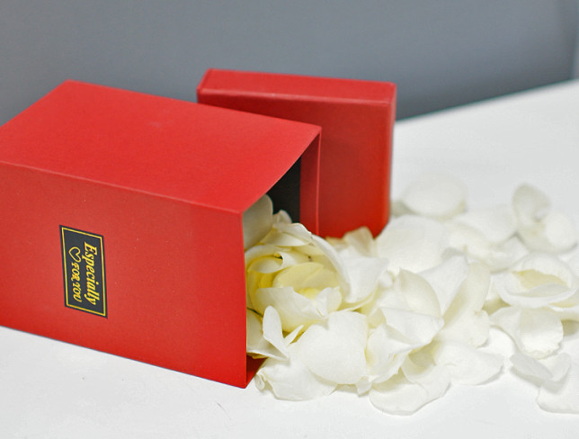 Коробочка с белыми лепестками роз Фото